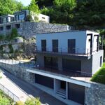 Villa moderna a Torno sul Lago di Como con 230 mq, vista lago panoramica a 180°, giardino privato di 250 mq, bio piscina, rooftop di 70 mq, 3 camere, terrazze e garage.